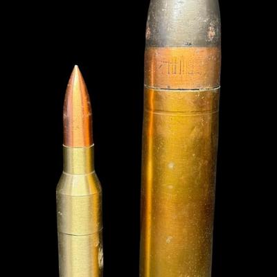 Sale Photo Thumbnail #541: Includes an inert shell casing, and a lighter bullet. Total of two pieces. Measurement of tallest: 8”H (shell). [JS]