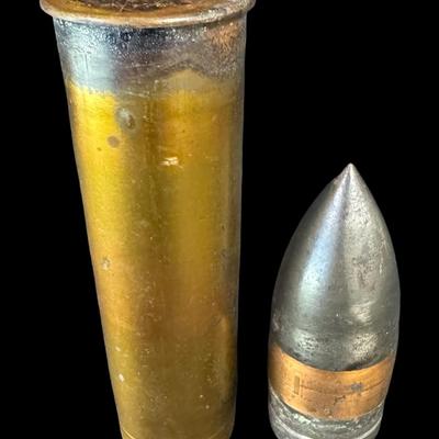 Sale Photo Thumbnail #542: Includes an inert shell casing, and a lighter bullet. Total of two pieces. Measurement of tallest: 8”H (shell). [JS]