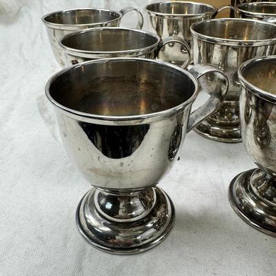 Sale Photo Thumbnail #195: These are vintage silver-plated punch cups, likely part of a larger punch bowl service. 

They are typically made of electro-plated nickel silver (EPNS). 
The cups feature a footed base and a single handle.
They are often part of a set including a punch b