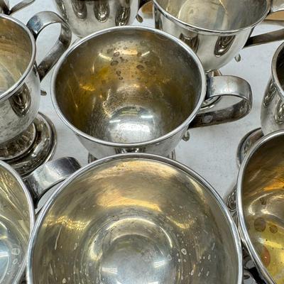 Sale Photo Thumbnail #202: These are vintage silver-plated punch cups, likely part of a larger punch bowl service. 

They are typically made of electro-plated nickel silver (EPNS). 
The cups feature a footed base and a single handle.
They are often part of a set including a punch b