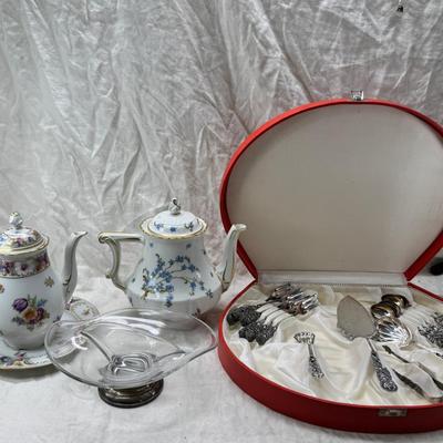 Sale Photo Thumbnail #203: Set of floral Hors d'oeuvre spoons, forks in original red case. Divided olive glass bowl with silver foot ( unmarked) 2 fine bone china tea pots one with matching plate.