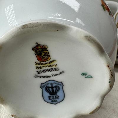 Sale Photo Thumbnail #211: Set of floral Hors d'oeuvre spoons, forks in original red case. Divided olive glass bowl with silver foot ( unmarked) 2 fine bone china tea pots one with matching plate.