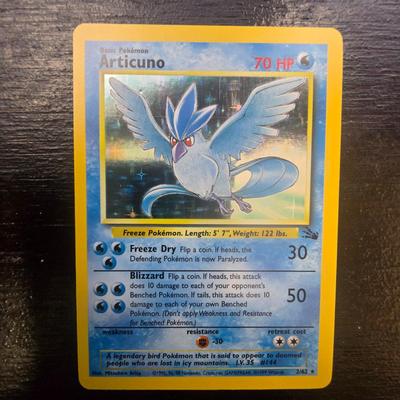 Sale Photo Thumbnail #3: Articuno Pokemon card from the Fossil expansion set, featuring holographic artwork. The card has 70 HP with attacks Freeze Dry (30 damage) and Blizzard (50 damage). Card text details possible effects on the opponent during gameplay. Light play. , details 
