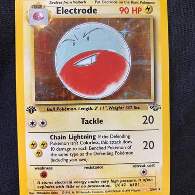 Sale Photo Thumbnail #71: Pokemon TCG Electrode card from the first edition base set. Features holofoil background. Card number 21/102. Published by Wizards of the Coast in 1999. Condition is light play, with minor surface and edge wear visible upon inspection.