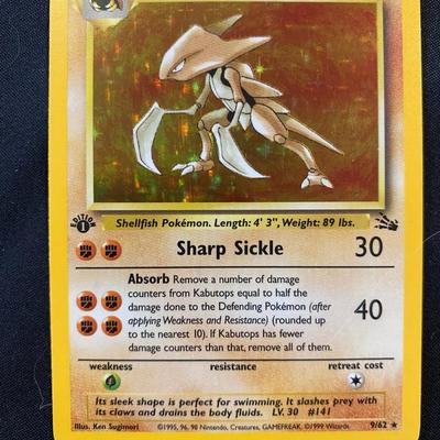 Sale Photo Thumbnail #91: This is a Kabutops holographic card from the Fossil set of the Pokemon Trading Card Game. The card features a holofoil background, is numbered 9/62, and has a 1999 copyright date. Condition is light play, with some minor wear visible. It evolves from Kabu