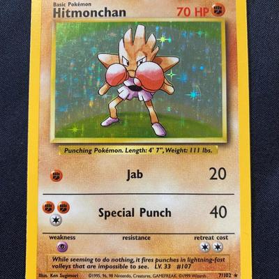 Sale Photo Thumbnail #95: Pokemon Trading Card Game Base Set Holo Hitmonchan card, #7/102. Features holographic artwork with 70 HP. Manufactured by Wizards of the Coast in 1999. Condition is classified as light play with signs of minimal use. Iconic card from the original Base Set