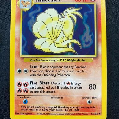 Sale Photo Thumbnail #127: PokÃ©mon Ninetales Holo card from the Base Set. Numbered 12/102, this card shows the holographic feature on its design and carries Stage 1 evolution of Vulpix with 80 HP. The card displays light play condition with noticeable wear but no major defects. 