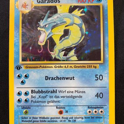 Sale Photo Thumbnail #133: This is a first edition holographic Gyarados from the Pokemon Trading Card Game series (Base Set, 1999). Card number is 6/102, published by Wizards of the Coast. Condition is noted as light play, with minor signs of handling typical for this grade. Featur