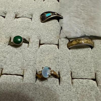 OPAL COLORED STONE RING IS 18K HGE, BEAR CLAW RING, RING WITH DOLPHINS AROUND BAND, AND A RING WITH GREEN STONE