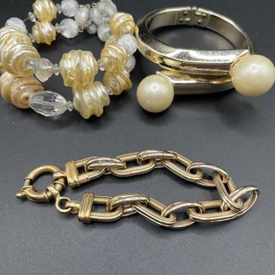 Cream and gold tone bracelets