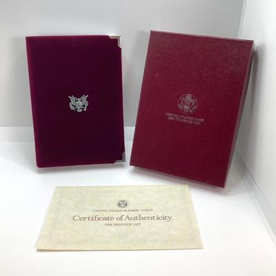 LOT 103: United States Mint 1988 Prestige Set with 1988 U.S. Olympic Silver Dollar in Presentation Book with Certificate of Authenticity