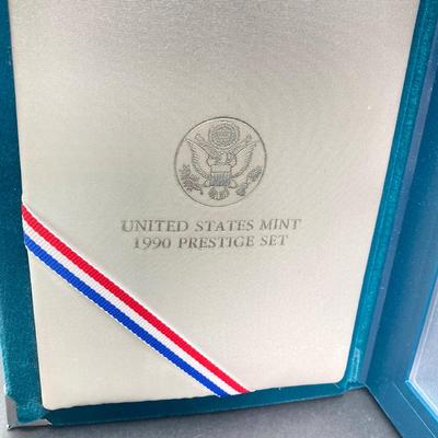 LOT 104: United States Mint 1990 Prestige Set with 1990 Eisenhower Centennial Silver Dollar in Presentation Book with Certificate of...