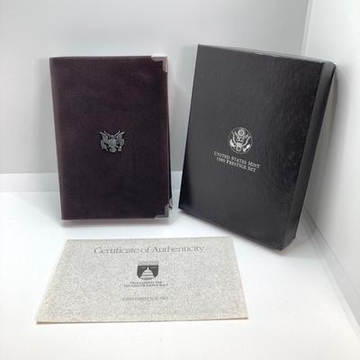 LOT 105: United States Mint 1989 Prestige Set with 1989 Congressional Silver Dollar and Half Dollar in Presentation Book with Certificate...