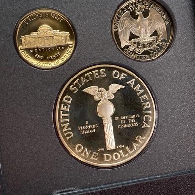 LOT 105: United States Mint 1989 Prestige Set with 1989 Congressional Silver Dollar and Half Dollar in Presentation Book with Certificate...