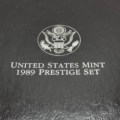 LOT 105: United States Mint 1989 Prestige Set with 1989 Congressional Silver Dollar and Half Dollar in Presentation Book with Certificate...