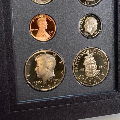 LOT 105: United States Mint 1989 Prestige Set with 1989 Congressional Silver Dollar and Half Dollar in Presentation Book with Certificate...