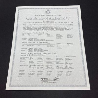 LOT 105: United States Mint 1989 Prestige Set with 1989 Congressional Silver Dollar and Half Dollar in Presentation Book with Certificate...