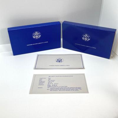 LOT 110: Pair of 1986 United States Liberty Coin Sets with Silver Dollar Coins in Presentation Boxes with Certificate of Authenticity
