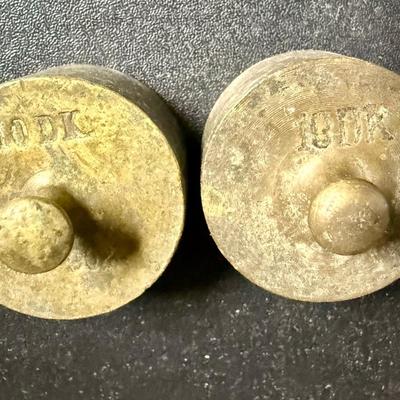 Sale Photo Thumbnail #668: Antique set of brass scale weights in a wooden box. 7 weights are included, the smallest one is missing.  Box hinge is broken.