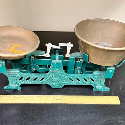 Sale Photo Thumbnail #673: This is a vintage or antique French cast iron balance scale, also known as a force or market scale, with brass pans.