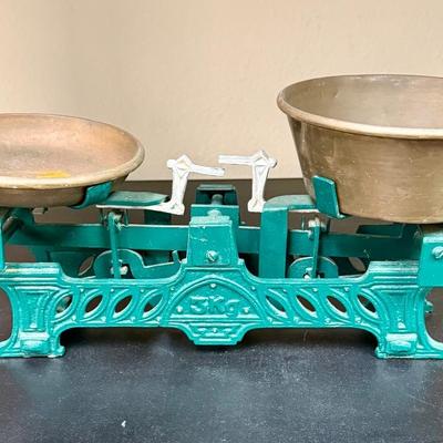 Sale Photo Thumbnail #671: This is a vintage or antique French cast iron balance scale, also known as a force or market scale, with brass pans.