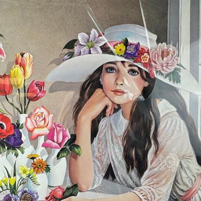 Sale Photo Thumbnail #359: This is a "Floribunda" lithograph print by the artist Pati Bannister The print is signed and numbered, with an edition size of 485.
It was created in 1988. The image features a young woman with long dark hair, wearing a white dress and a wide-brimmed hat 