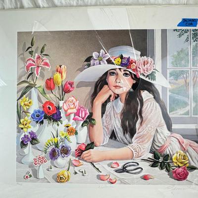 Sale Photo Thumbnail #358: This is a "Floribunda" lithograph print by the artist Pati Bannister The print is signed and numbered, with an edition size of 485.
It was created in 1988. The image features a young woman with long dark hair, wearing a white dress and a wide-brimmed hat 