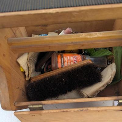 vintage shoe shine kit, which includes a wooden storage box, brushes, cloths, and several tins of shoe polish