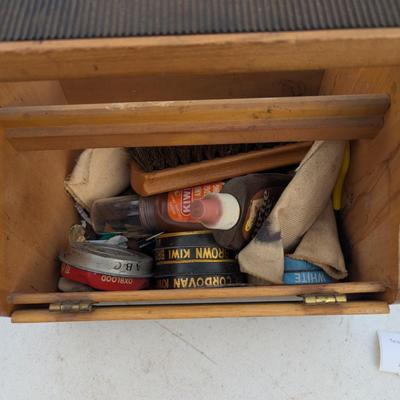 vintage shoe shine kit, which includes a wooden storage box, brushes, cloths, and several tins of shoe polish