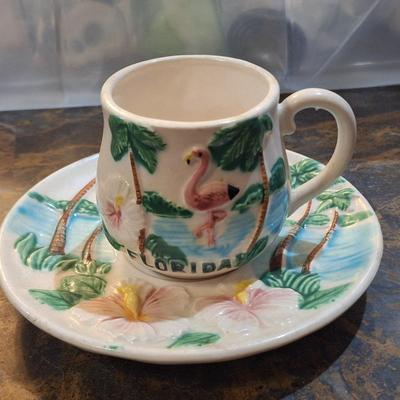 vintage Florida souvenir ceramic demitasse cup and saucer set featuring a pink flamingo and palm trees.