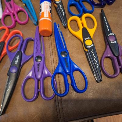 assortment of craft scissors, glue sticks and colored pencils