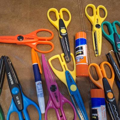 assortment of craft scissors, glue sticks and colored pencils
