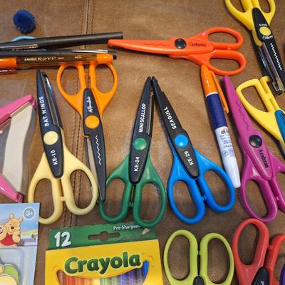 assortment of craft scissors, glue sticks and colored pencils