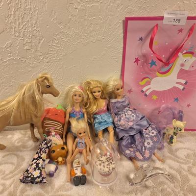 various dolls and toys, barbie, horse and other items all in a unicorn bagq