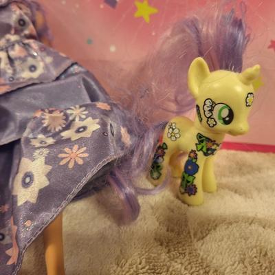 various dolls and toys, barbie, horse and other items all in a unicorn bagq