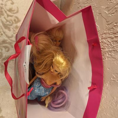 various dolls and toys, barbie, horse and other items all in a unicorn bagq