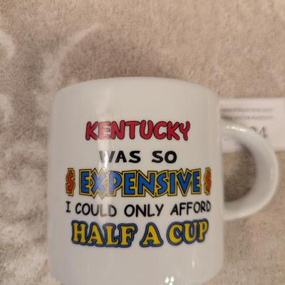 souvenir ceramic mug with the text "KENTUCKY WAS SO EXPENSIVE I COULD ONLY AFFORD HALF A CUP