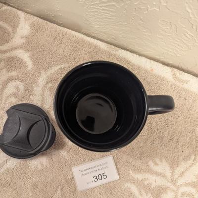 black ceramic mug with a cork base and lid, featuring the Comanche Nation "Lords of the Plains" logo