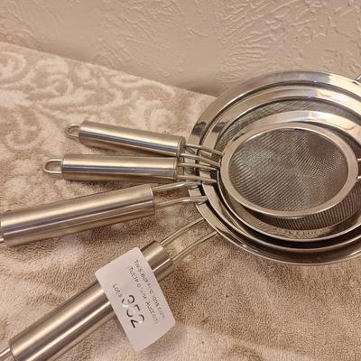 Set of stainless steel fin mesh strainers.