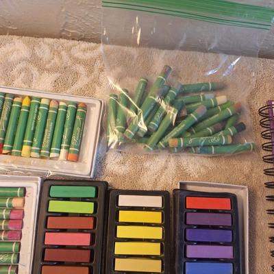 Sketchbook and a set of soft art pastels as well as some oil pastels.  The sketch book has one page with drawings on it.