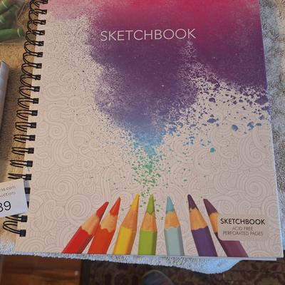 Sketchbook and a set of soft art pastels as well as some oil pastels.  The sketch book has one page with drawings on it.