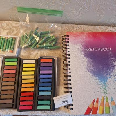 Sketchbook and a set of soft art pastels as well as some oil pastels.  The sketch book has one page with drawings on it.