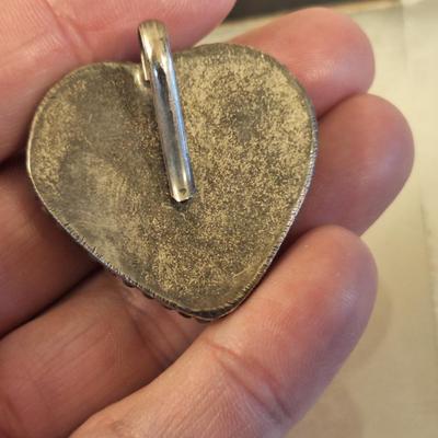 heart shaped pendant or scarf clip.  See photo of back it does not fully close, it slips over something.