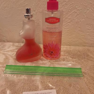 Left: A bottle of Creation Lamis Catsuit Eau de Parfum for Women.  Right: A bottle of Sheer Attraction by Intimate Silkening Body Mist in...