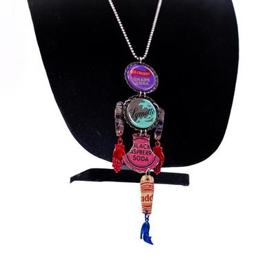 Sale Photo Thumbnail #425: This is an upcycled, industrial- inspired bottle cap necklace featuring various soda bottle caps, including "Old Colony Grape Soda,' "Lymette," and "Black".