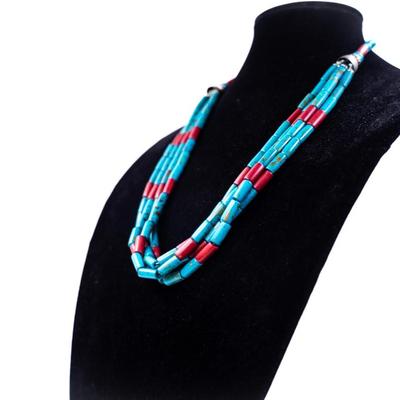 Sale Photo Thumbnail #431: This is a multi-strand Native American turquoise and coral beads necklace, possibly featuring a jacla pendant and silver accents.