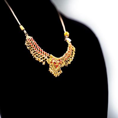 Sale Photo Thumbnail #436: This is a multicolor stone-studded traditional Indian necklace, possibly a kundan or jadau style, with matching turquoise and red bead necklace visible in the background.