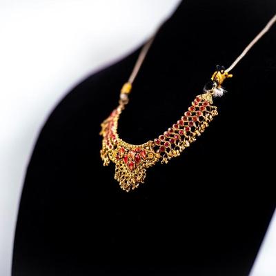 Sale Photo Thumbnail #435: This is a multicolor stone-studded traditional Indian necklace, possibly a kundan or jadau style, with matching turquoise and red bead necklace visible in the background.