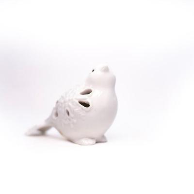 Sale Photo Thumbnail #441: This is a ceramic bird figurine with decorative cutouts. The figurine features a glossy finish and intricate cutouts on its body.