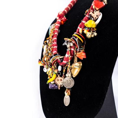 Sale Photo Thumbnail #451: This is a handcrafted charm neckace featuring a hand-dyed scarf base approximately 56 milagros and charchkas from around the world.